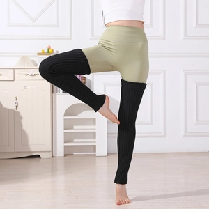Détail de jambières en maille côtelée noire portées sur un legging de yoga