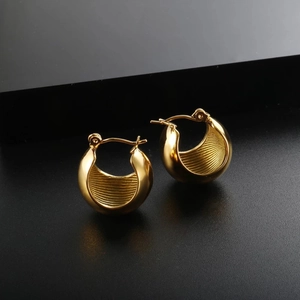 Macro detail of gold-plated U-shaped hoop earrings with inner vertical line texture