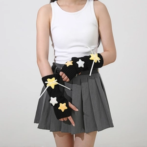 Detail of black knit fingerless arm warmers with yellow sequin stars and white ribbon bows