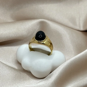 Vintage-Ring mit 18k Vergoldung und ovalem schwarzem Onyx auf weißem Wolkenständer