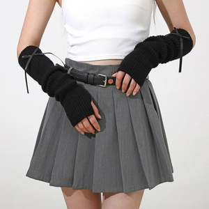 Détail de manchettes en tricot noir avec des nœuds en ruban et une texture côtelée