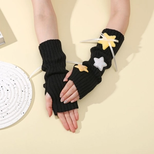 Detail of black knit arm warmers with plush yellow stars and white ribbon accents