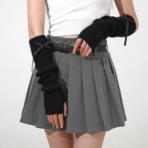 Détail de mitaines en tricot noir avec un petit nœud de style Y2K et JK