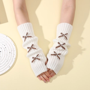 Detail of cream knit arm warmers with plaid bows and fingerless design for women