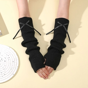 Détail de mitaines en tricot côtelé noir avec nœuds décoratifs et design sans doigts