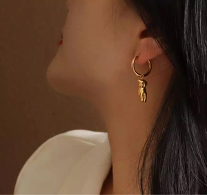 Vue détaillée d'un pendentif corps de femme plaqué or 18k sur une boucle d'oreille