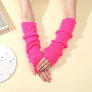 Detail of neon pink knitted fingerless arm warmers with a wavy hem and ribbed texture