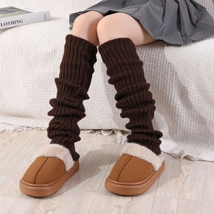 Détail de jambières en maille marron foncé avec des chaussons d'hiver en peluche douce