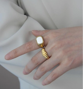 Primer plano de set de anillos dorados con nácar blanco y diseño de croissant
