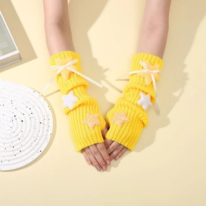 Close-up of yellow knit arm warmer featuring plush stars and ribbon bow detail