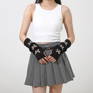Detail of black Y2K knit arm warmers with bow accents and fingerless design