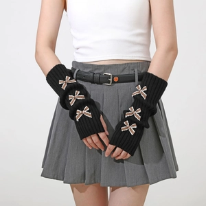 Detail view of black knitted arm warmers featuring cute brown plaid bow ties and ribbed cuffs