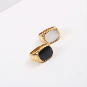 Detalle de dos anillos de acero chapado en oro 18K con esmalte negro e incrustación de nácar