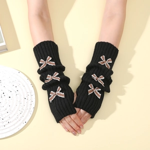 Detail of black knit arm warmers with brown striped bows and ribbed texture