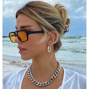 Collana a catena cubana con orecchini a cerchio e occhiali da sole al mare