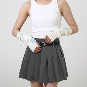 Detailed knit texture of white Y2K arm warmers with colorful sequins and bow tie