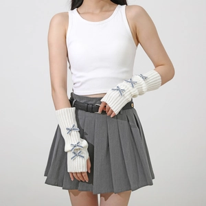 Detail of white rib-knit arm warmers featuring blue bow accents in Y2K aesthetic style
