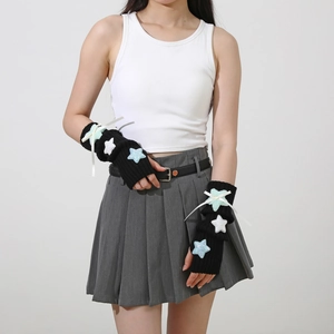 Close-up of black knit arm warmers featuring blue plush stars and white silk bows