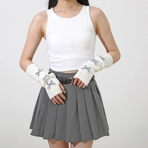 Detail of cream knit arm warmers with blue bow accents and fingerless design