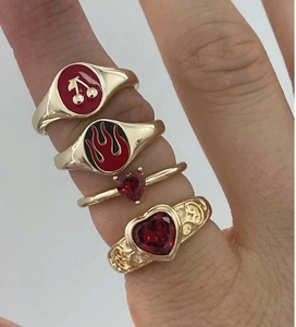 Dettaglio del set di anelli a cuore placcati oro 18K con motivi a ciliegia e fiamme