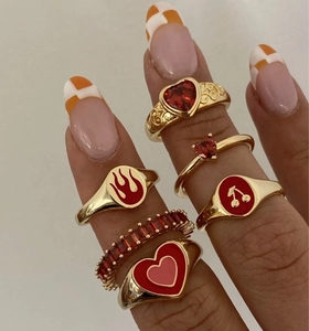 Dettaglio del set di anelli placcati oro 18K con cuori rossi e motivi di ciliegie smaltate