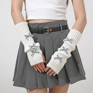 Detail of white knit arm warmers featuring blue plaid bow accents in Y2K style