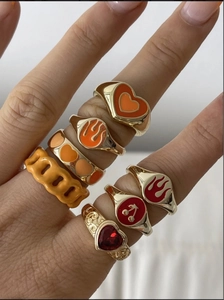 Dettaglio di un set di anelli placcati oro 18K con cuori in smalto e zirconi AAA