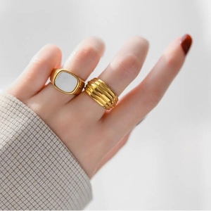 Anillos de acero inoxidable chapados en oro 18K con nácar blanco y diseño de ondas sutil