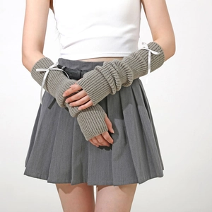 Détail de mitaines en tricot gris avec nœuds blancs et motifs à côtes verticales