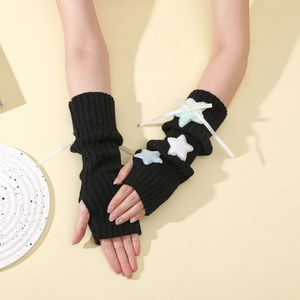 Detail of Y2K knitted arm warmers with plush stars and elegant white silk ribbons