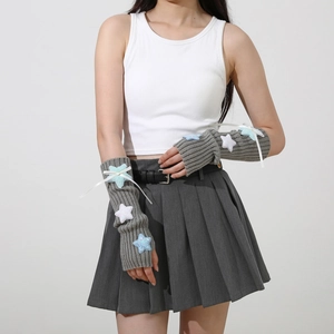 Detail of grey knitted arm sleeves with blue sequin stars and white ribbon bow accents