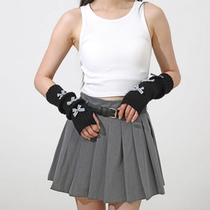 Detail of black knit arm warmers with blue checkered bows and ribbed texture