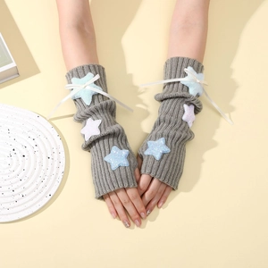 Detail of grey knitted arm warmers featuring plush stars and ribbon bow accents