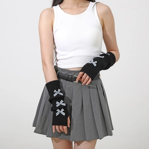 Detail of black rib-knit arm warmers with blue bow accents and fingerless design