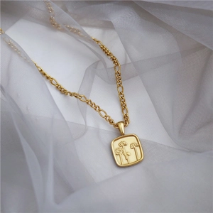 Elegante gouden madeliefjesketting met een Figaro-ketting op zachte witte stof