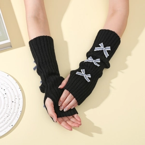 Detail of black knit arm warmers with blue checkered bows in a Y2K aesthetic style