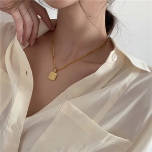 Elegante gouden madeliefjesketting met gegraveerde rechthoekige hanger op het sleutelbeen
