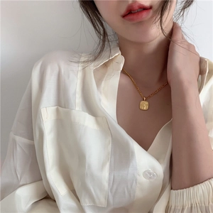 Elegante gouden ketting met vierkante madeliefjesreliëf gedragen door model