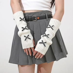 Close-up of white knitted arm sleeves featuring cute bows and vertical ribbed texture