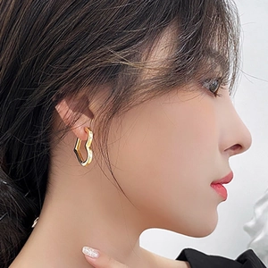 Gros plan de boucles d'oreilles minimalistes en forme de cœur en acier doré 18 carats