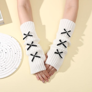 Detail of white knit arm warmers with black striped bows and thumb hole design