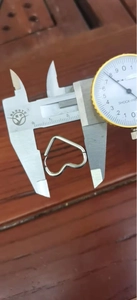 Mesure d'une boucle d'oreille en cœur de 15 mm en acier avec un pied à coulisse
