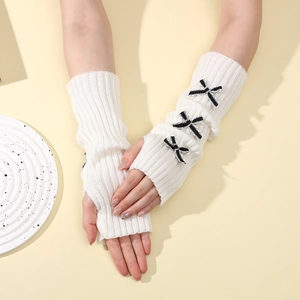 Close-up of white rib-knit fingerless gloves featuring three striped bow decorations