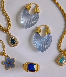 Dettaglio del set di gioielli placcati in oro con pietre di resina blu e fiori smaltati