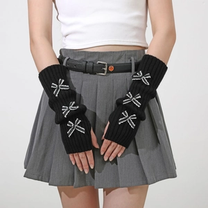 Detail of black knit arm warmers with white striped bows and vertical ribbed texture