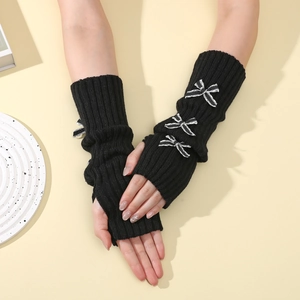 Detail of black rib-knit arm warmers with three striped bow accents and fingerless design