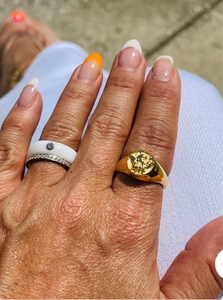 Dettaglio dell'anello a sigillo ali di angelo dorato con fascia in ceramica e zircone