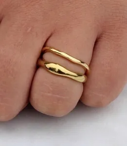 Primer plano de anillo dorado irregular de doble capa con acabado de metal pulido