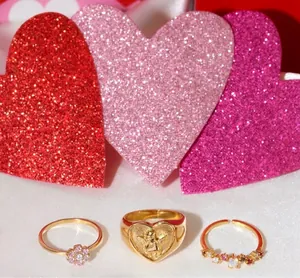 Set de tres anillos dorados con relieve de ángel y flores de circonita de colores