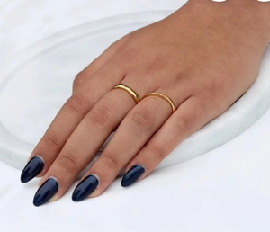 Primer plano de anillos minimalistas de acero inoxidable dorado con lunares